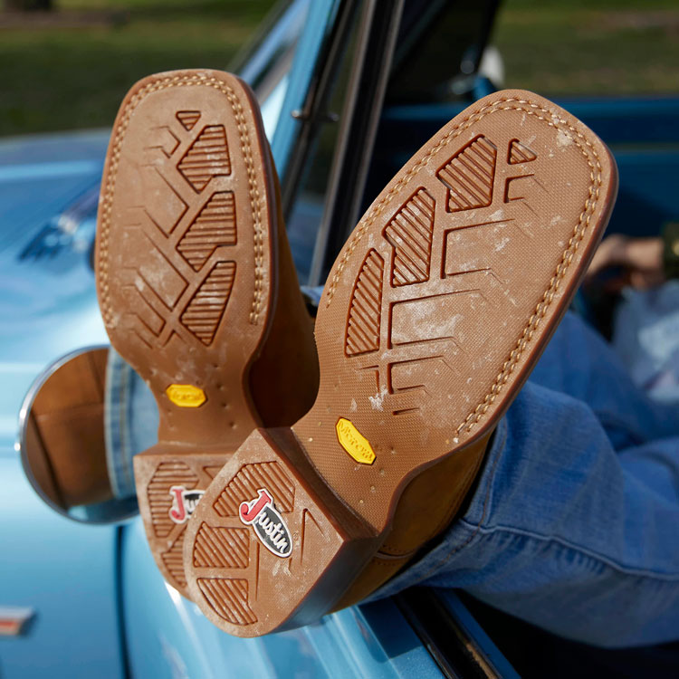 A close-up of the outsoles on a pair of Justin cowboy Boots.